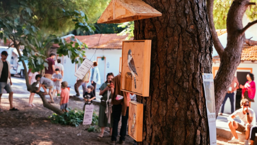 Tree with art and people in background at outdoor event