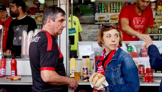 People buying food and drinks at a concession stand.