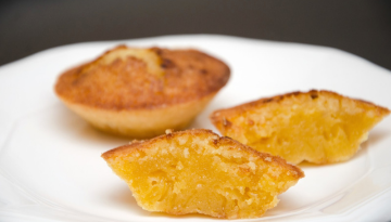 Two halves of a citrus muffin on a white plate.