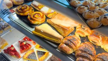 Assorted pastries displayed in a bakery case, including croissants and danishes.