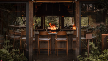 Cozy restaurant interior with wooden chairs and a central fire pit.