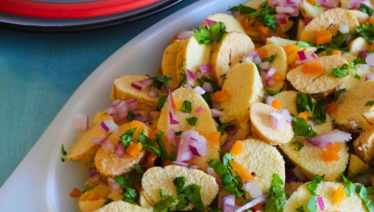Sliced bread with herbs and diced vegetables on a plate.