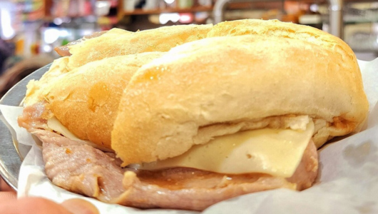 Close-up of a ham and cheese sandwich on a plate.