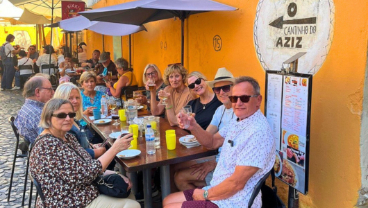 Group of people dining outdoors at a restaurant table.