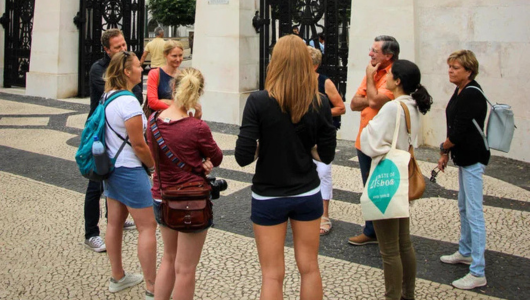 Group of people talking outdoors on a patterned pavement.