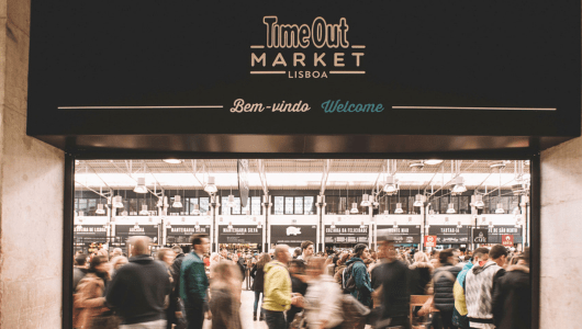 Crowded entrance of Time Out Market Lisboa with people walking.