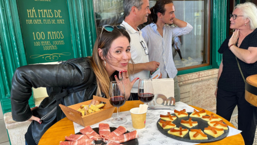 People enjoying wine and charcuterie at an outdoor table.