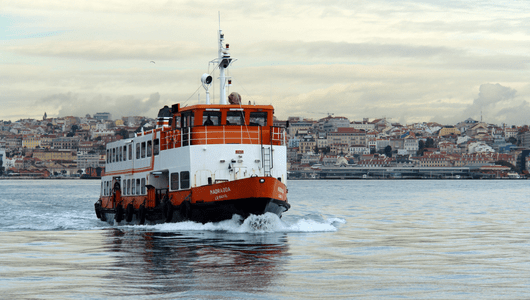 Ferryboat on water with cityscape in the background.