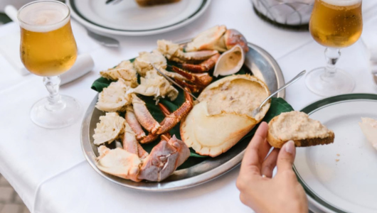Seafood platter with crabs and a sauce, served with beer.