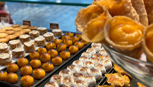 Assorted pastries on display, including cream-filled cones and round, glazed sweets.