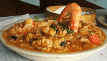 Plate of seafood risotto with shrimp and herbs.