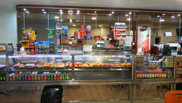 Snack bar counter with pastries, drinks, and snacks displayed.