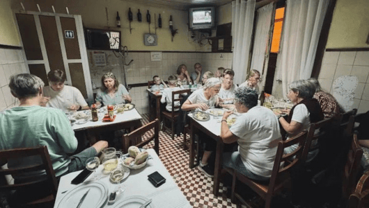 Group of people dining in a small restaurant with vintage decor.