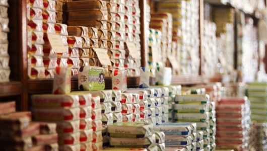 Shelves filled with neatly stacked colorful tins in a store.