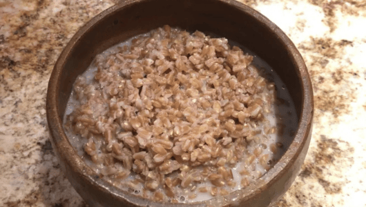 Bowl of oatmeal with milk on a granite countertop.