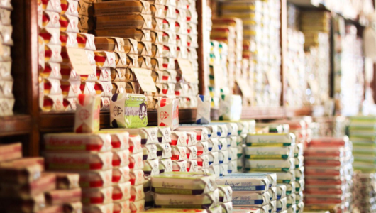 Stacks of colorful packaged goods on shelves in a store.